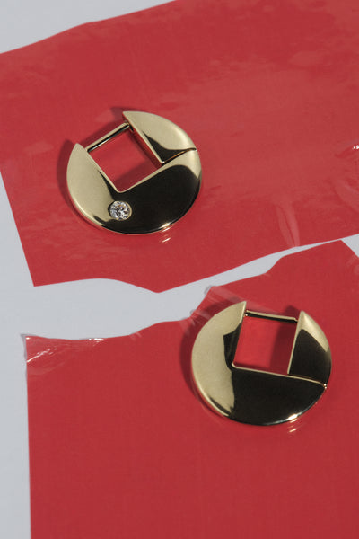 
            OUVERTURE  Berlin fine jewelry - Gold earrings with a black center on a red background